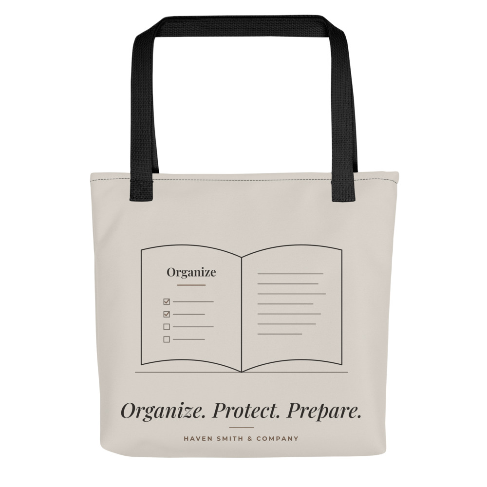 A bone tote with black handles printed with an open book drawing and Organize. Protect. Prepare.