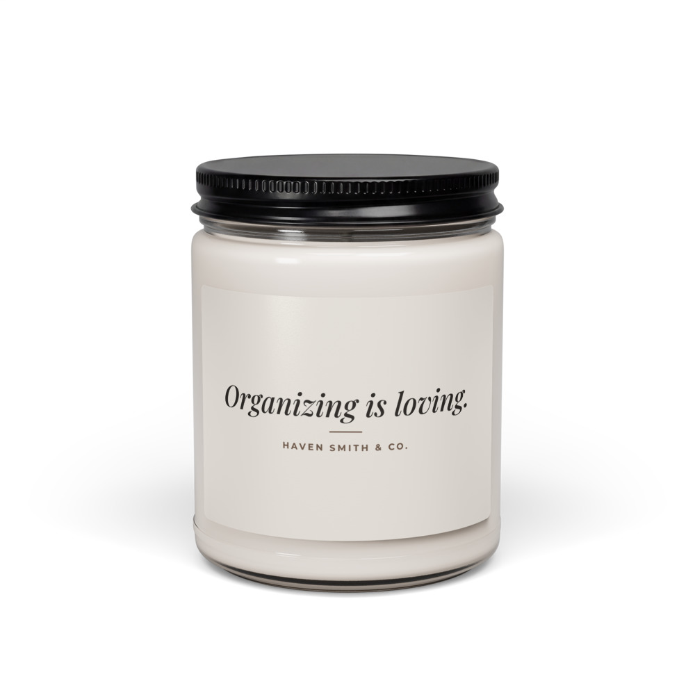 A white soy candle in a glass jar with a black lid, labeled Organizing is loving, Haven Smith and Co.