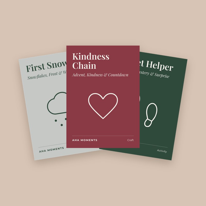 Three Christmas cards fanned out: First Snow, Kindness Chain, and Secret Helper